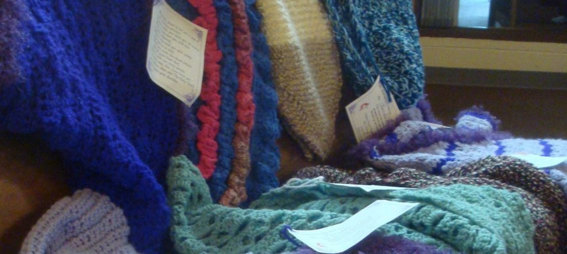 Missions and Outreach - Prayer Shawl Ministry. Colorful knitted blankets and scarves made and draped over the pews of the sanctuary