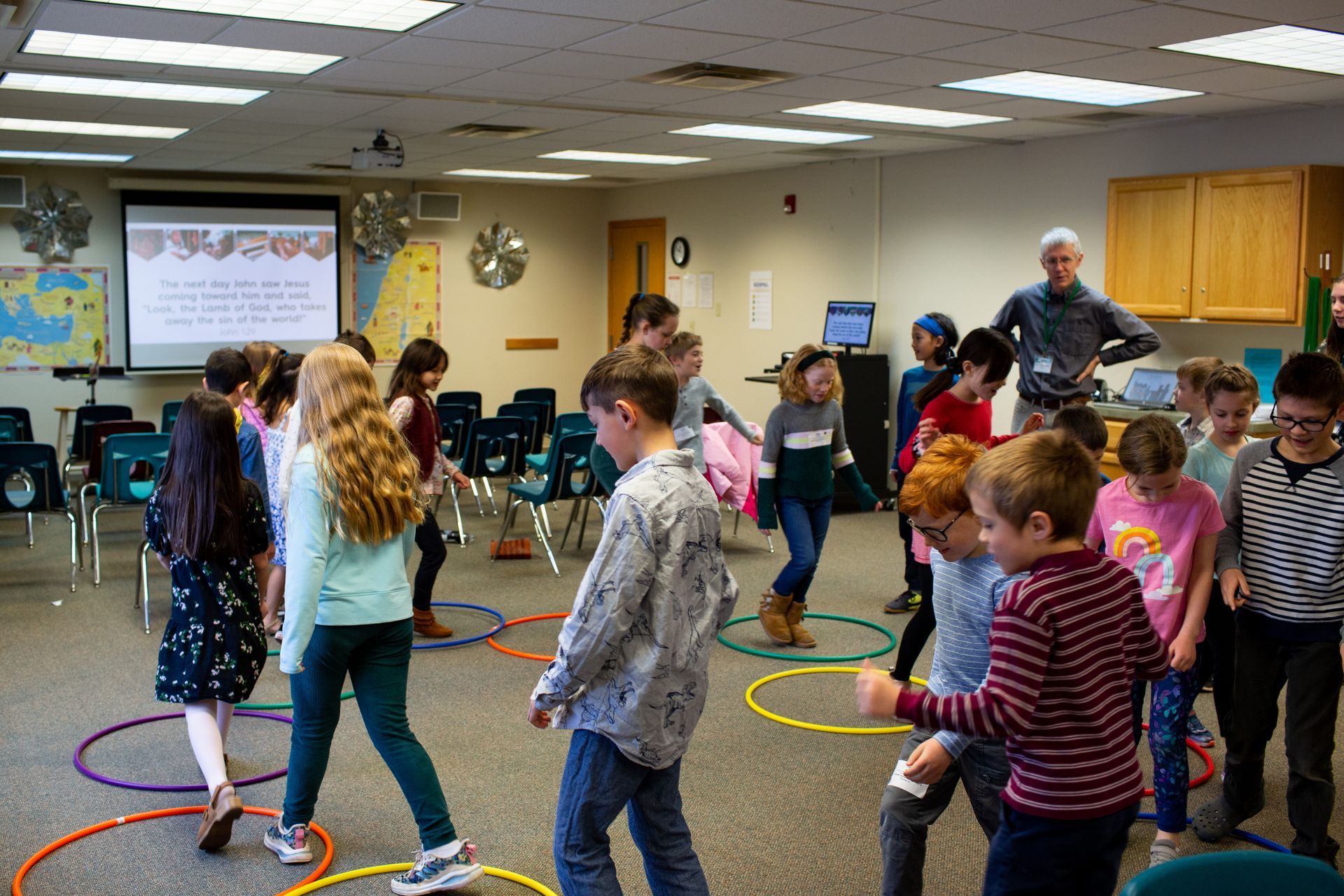 a group of children are playing with hula hoops in a classroom .