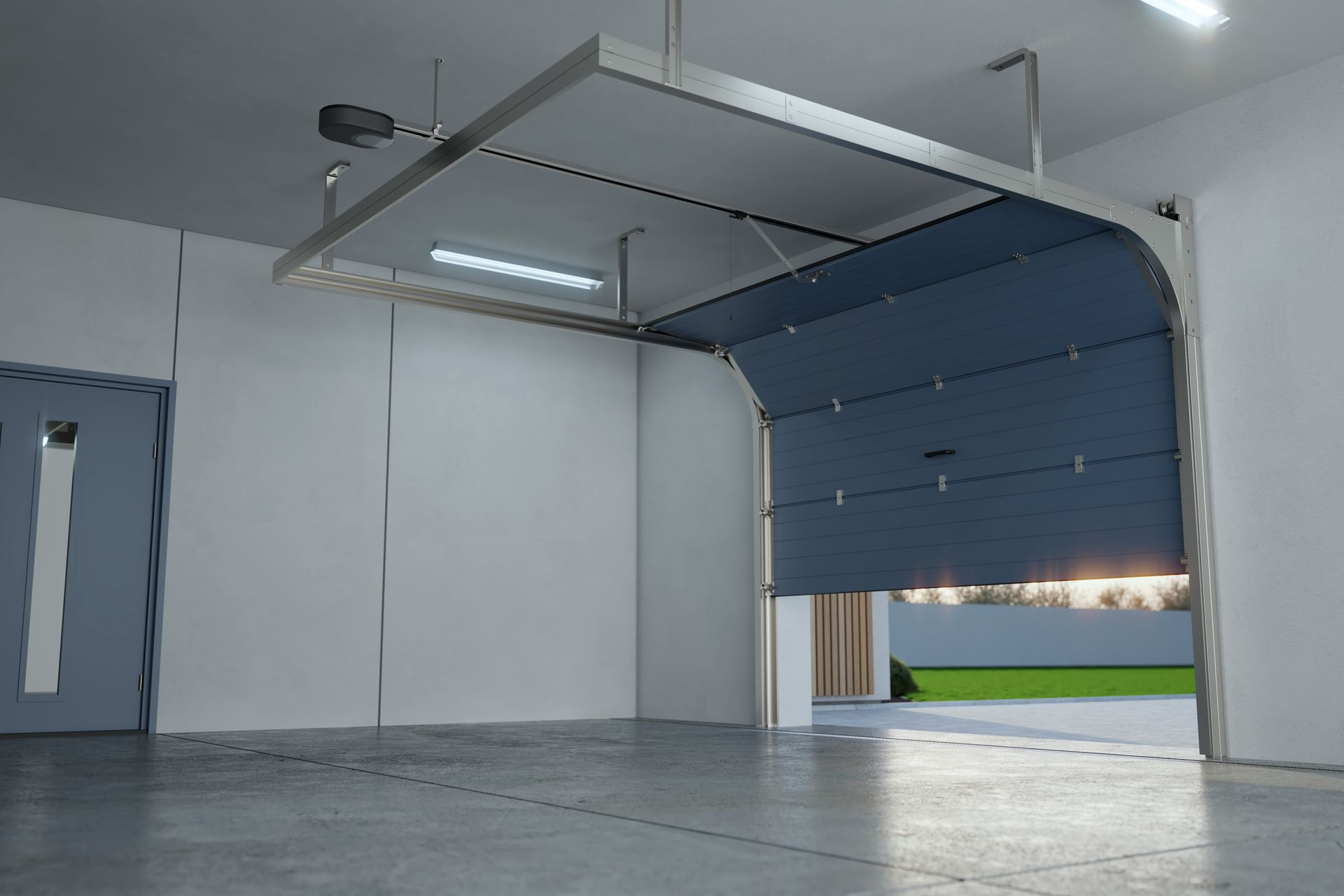 Empty garage with a blue roll-up door partially open and an exposed ceiling lift mechanism.