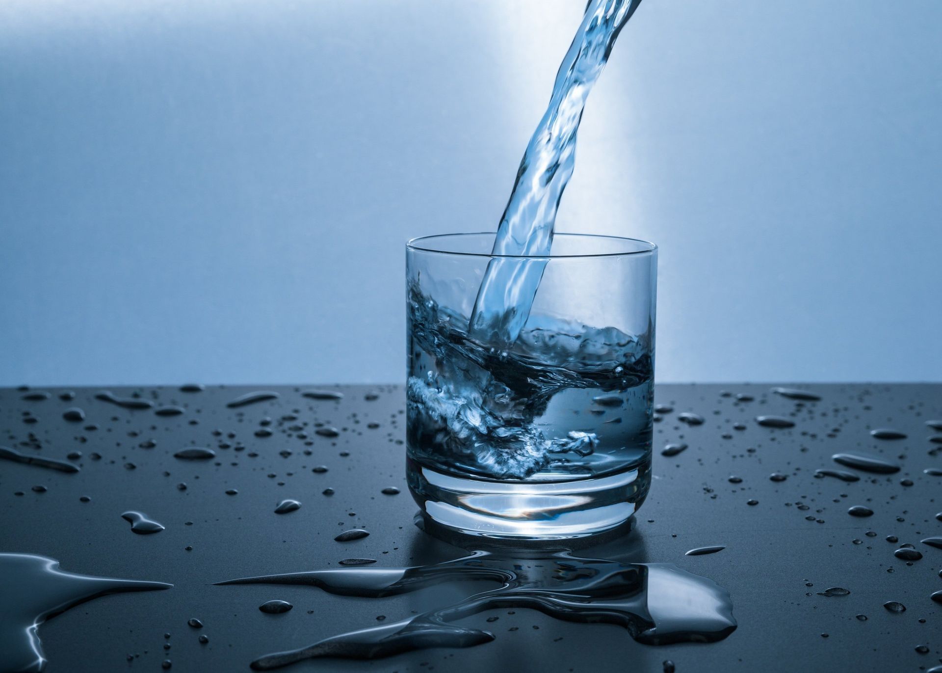 De l'eau est versée dans un verre sur une table.