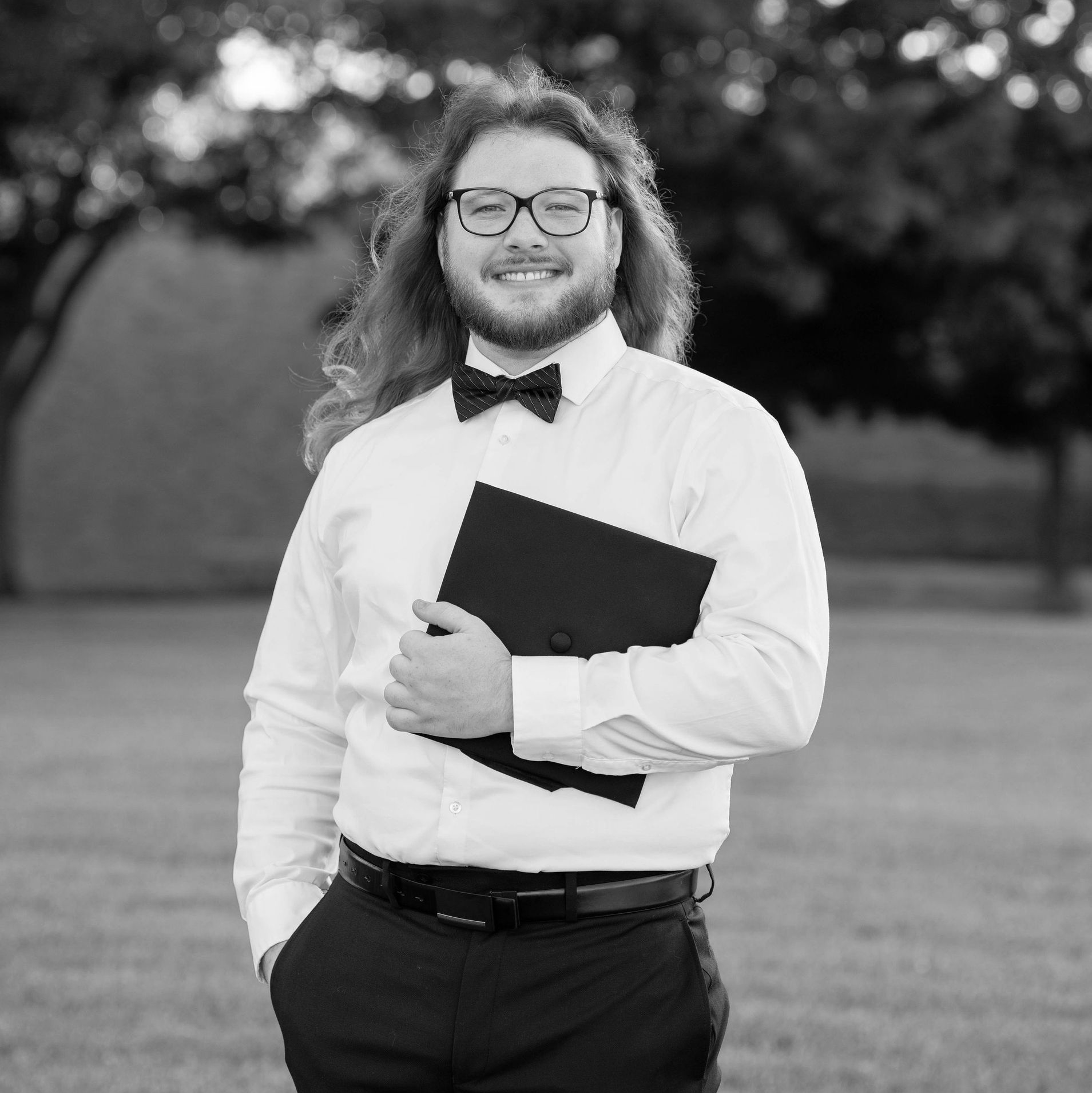 Austin Britten smiling and holding a graduation cap