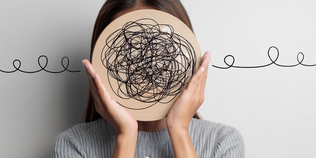 Person holding a plate with a scribbled tangled line over their face, with a wavy line in the background