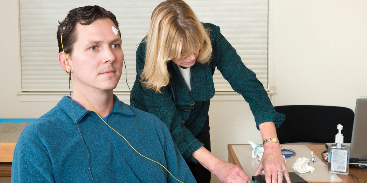 Healthcare worker checking a seated patient’s blood pressure in a clinic room