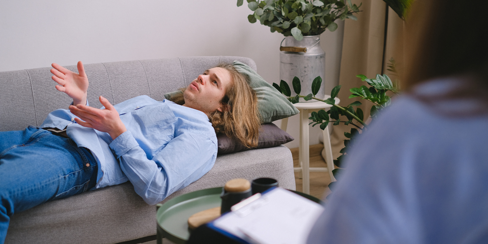 Woman lying on a therapy couch, talking with a counselor in an office setting