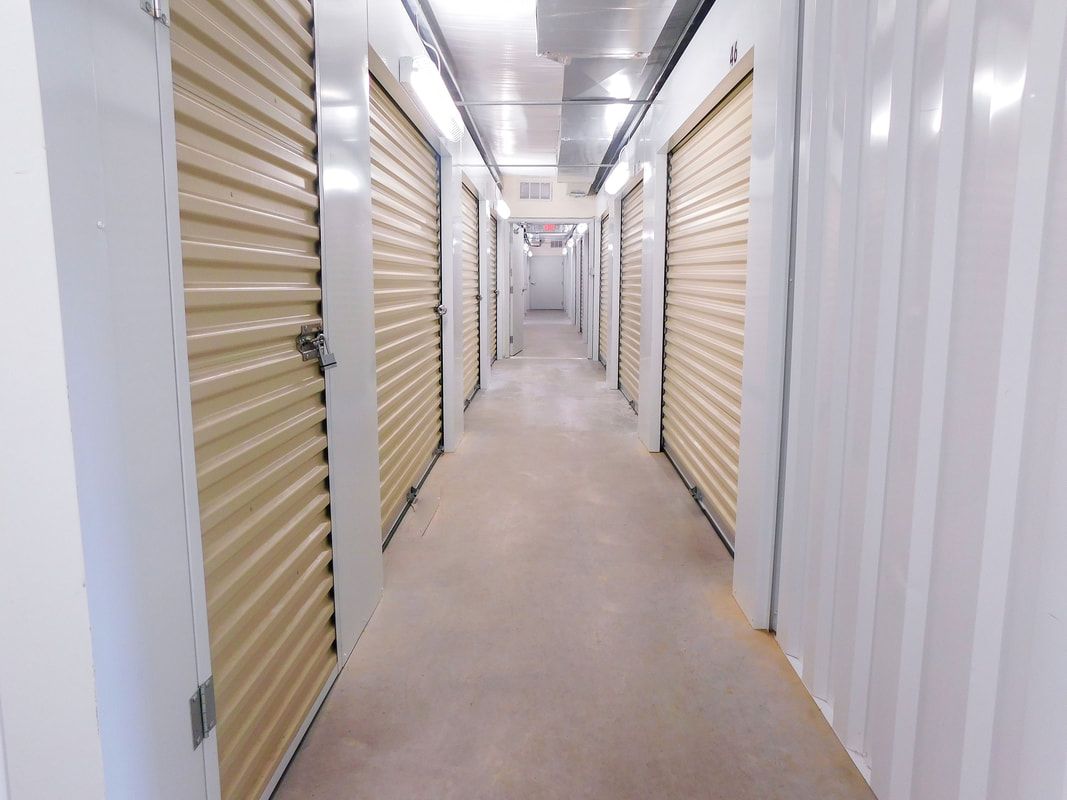 Long hallway lined with beige storage unit doors.
