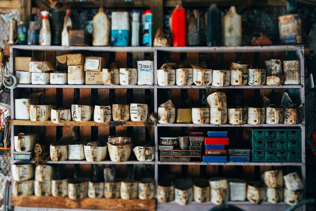 Shelves stocked with numerous small, ceramic containers and bottles, cluttered setting.