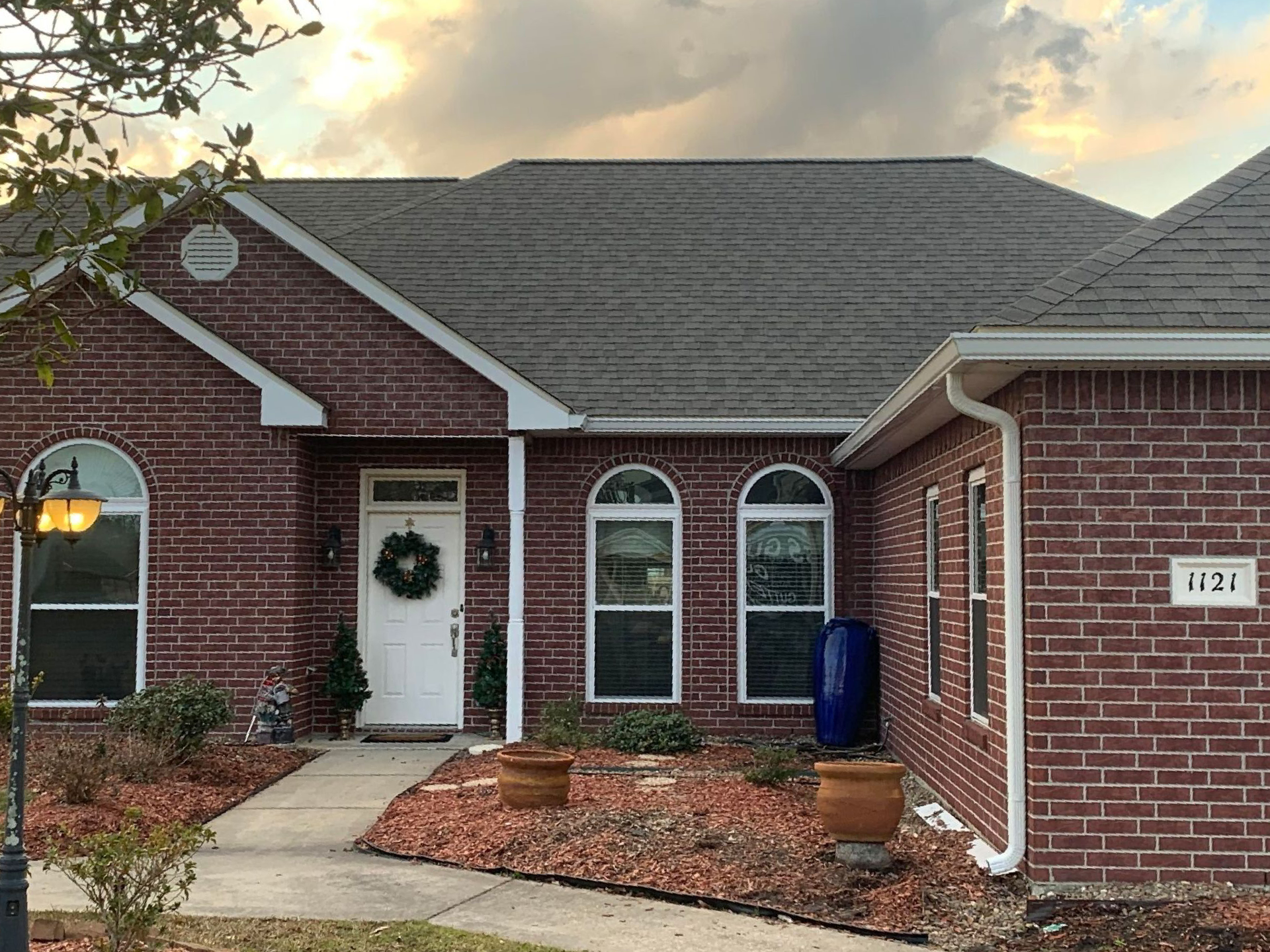 A brick house with arched windows and a gray roof