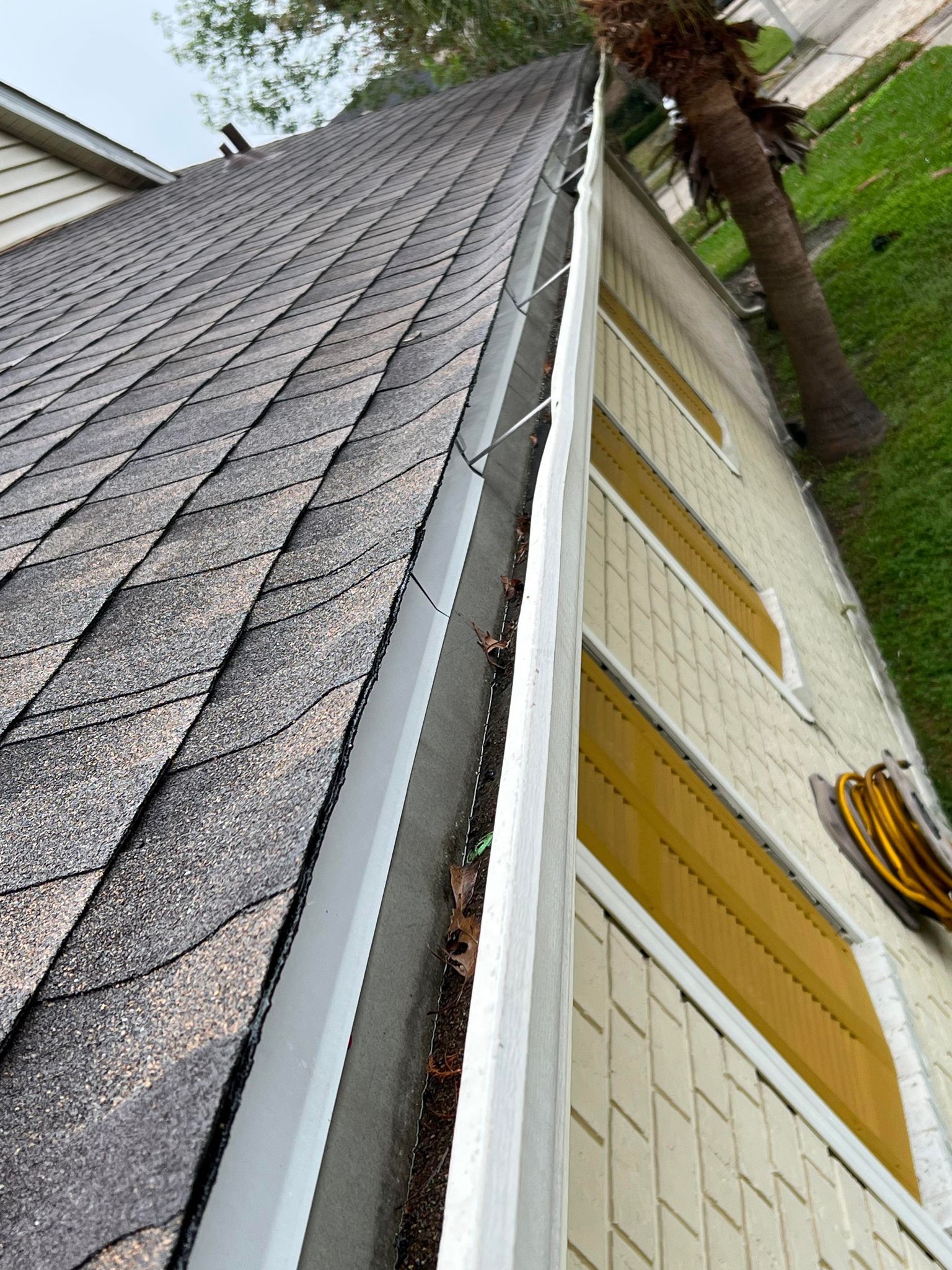 A close up of a gutter on the side of a house.