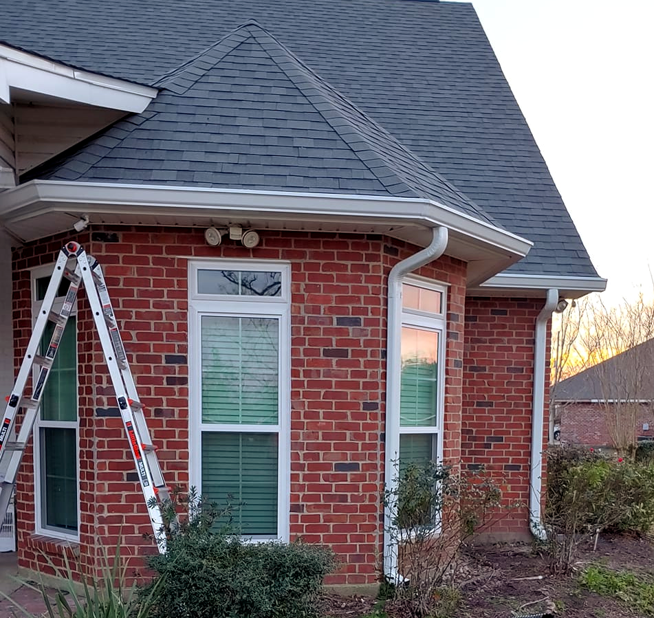 A brick house with a ladder leaning against it