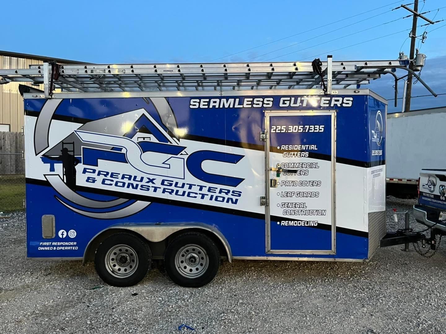 A blue and white trailer for seamless gutters and construction