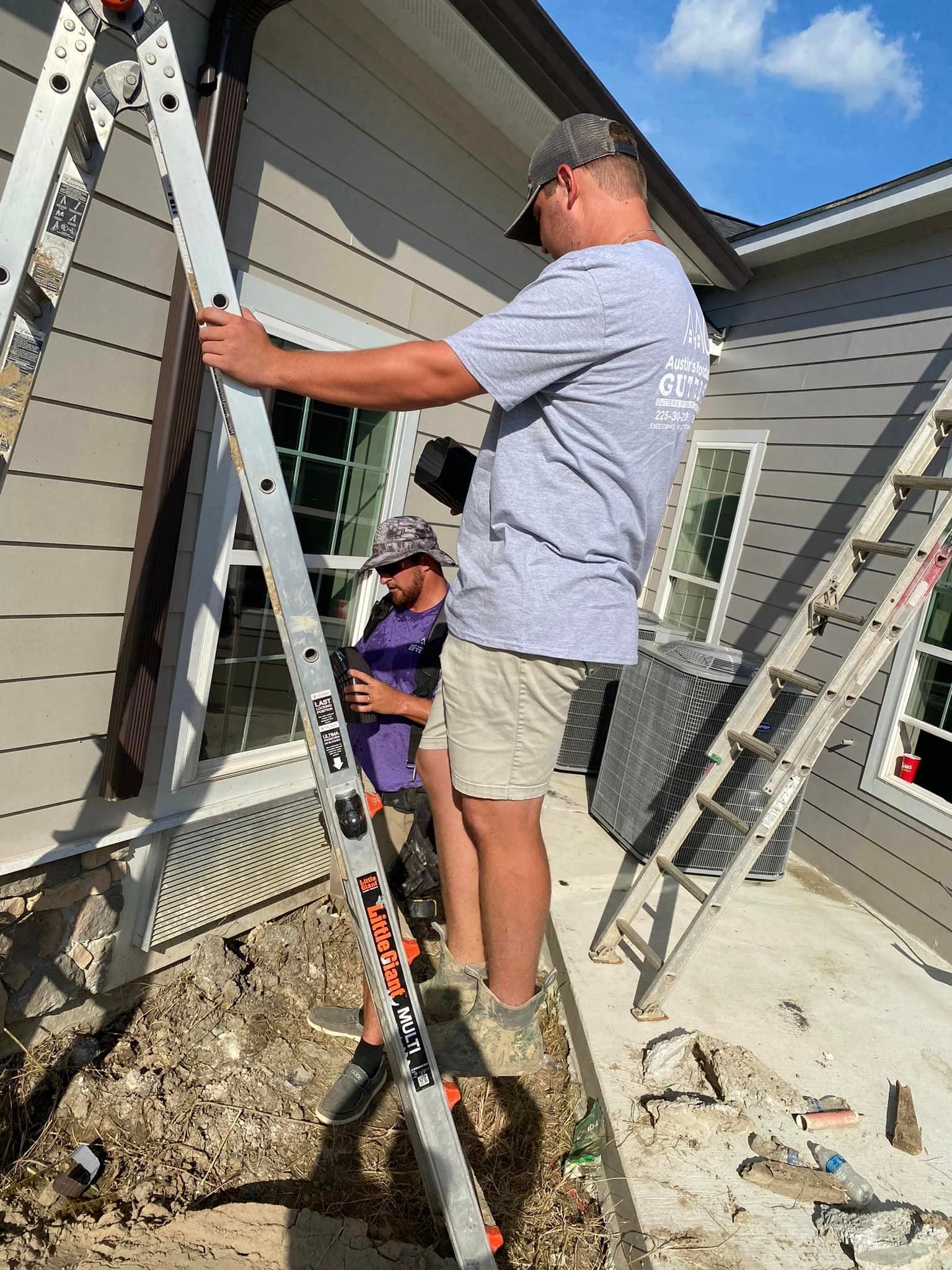 A man is standing on a ladder in front of a house.
