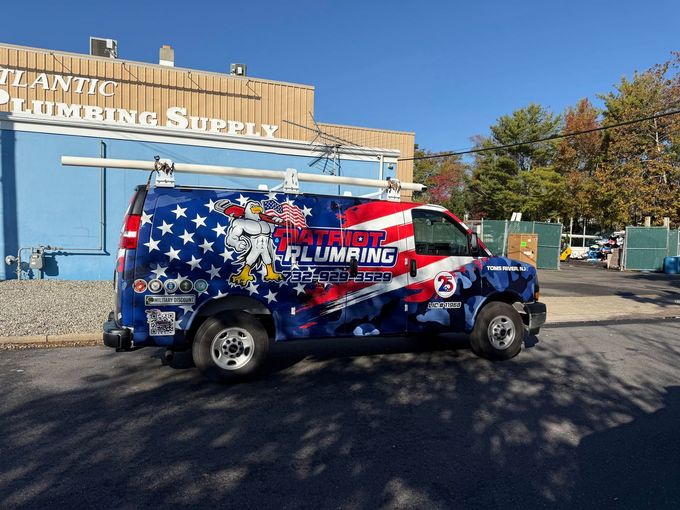 Patriotic wrapped van parked outside a furniture store, with American flag graphics and red, white, and blue colors