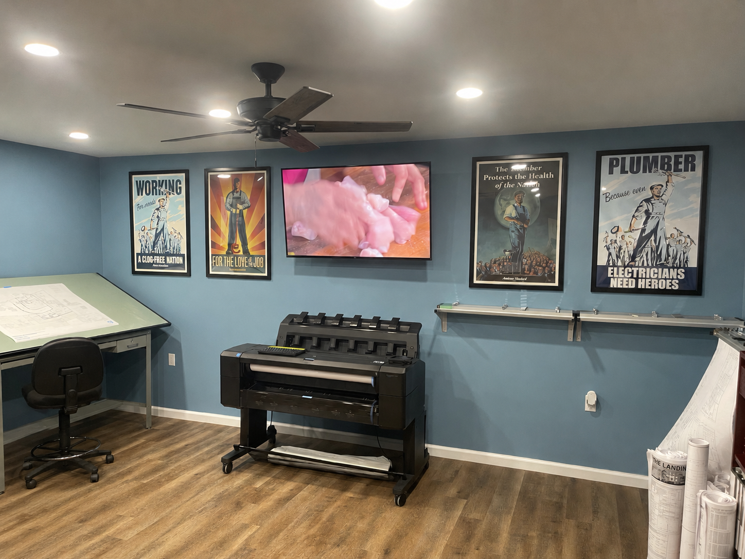 Basement room with blue walls, TV, stove, posters, and fireplace tools.