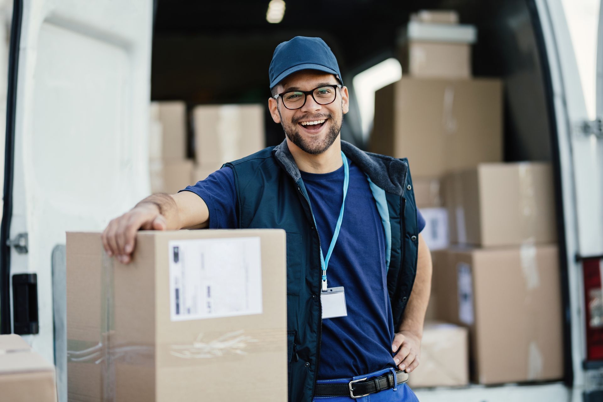 Delivery driver loading packages into a van, prepping for daily route work for delivery service