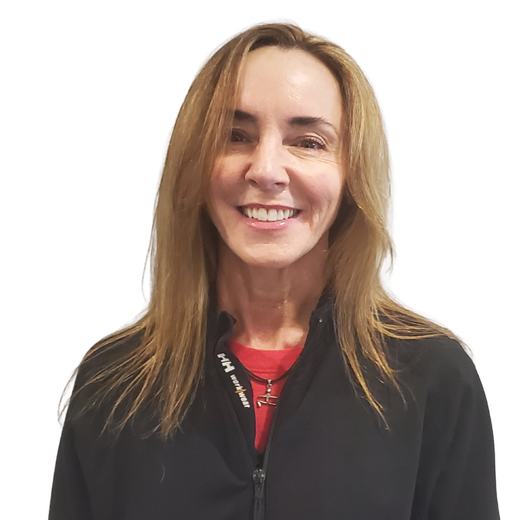Smiling person with long light brown hair wearing a black jacket over a red shirt on a white background