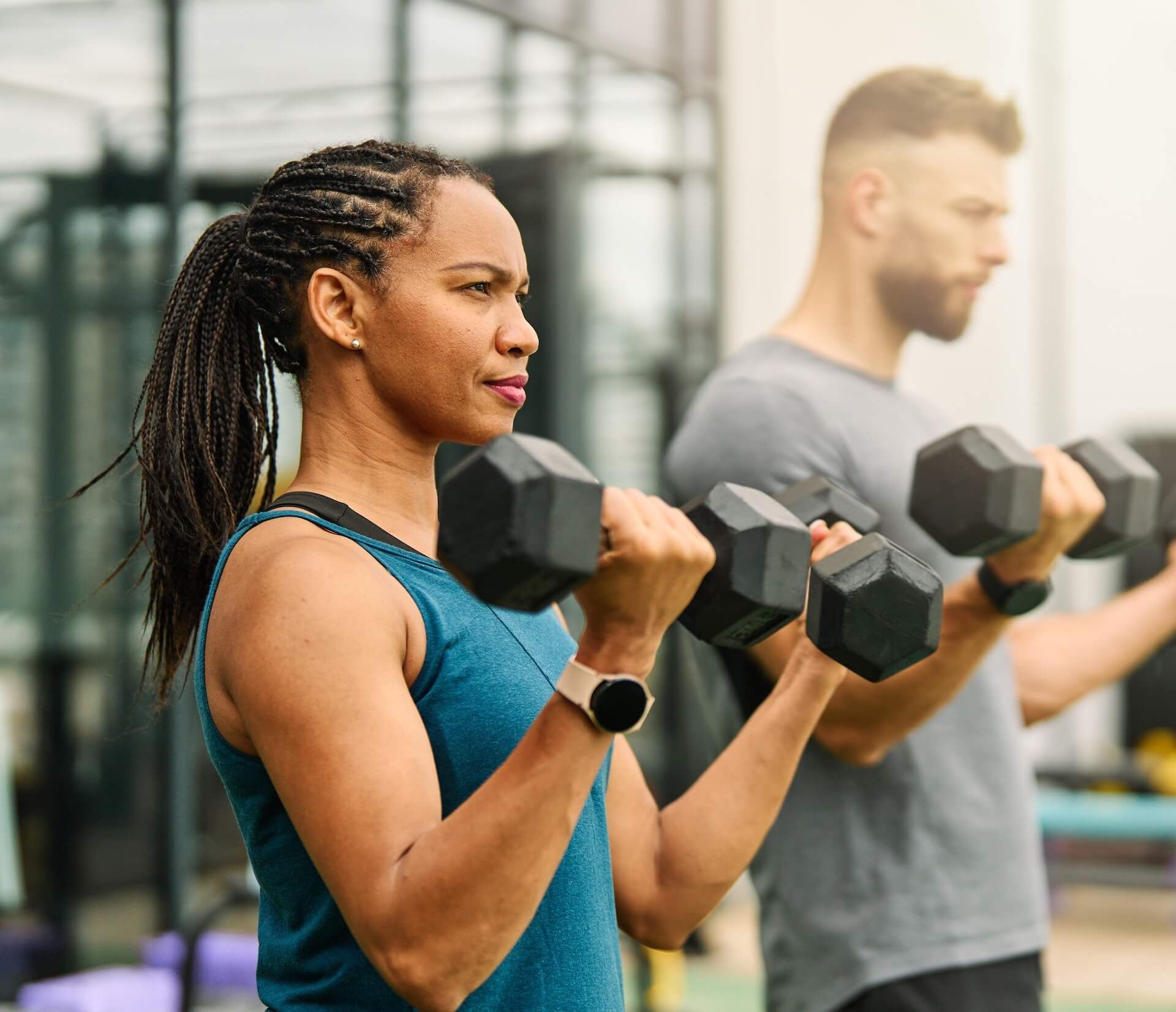 Group of people in workout clothes high-fiving in a gym, with a timer on the wall.