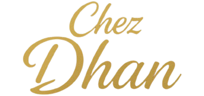 Logo de « Chez Dhan » en lettres dorées sur fond blanc.