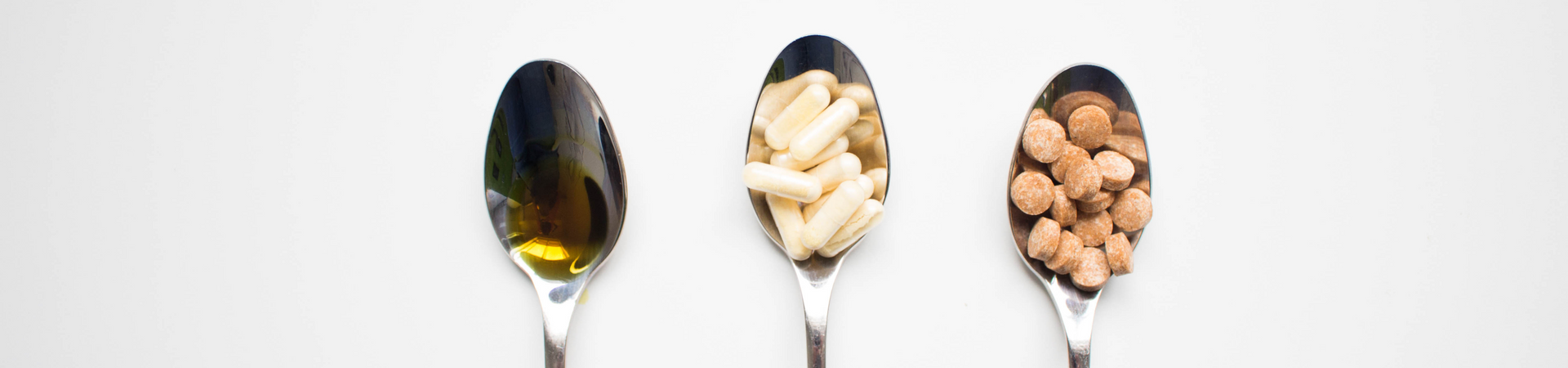 Spoons holding oil, vitamins and nuts