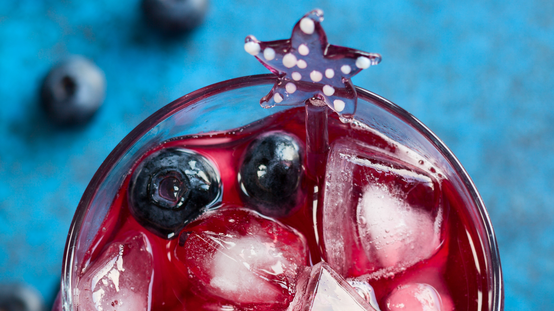An aerial view of a red-coloured mocktail with a star-shaped stirring straw