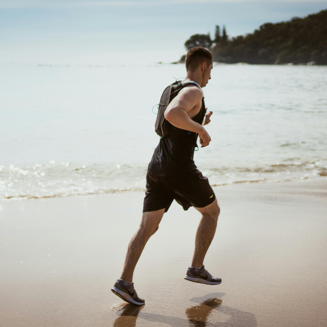 physically fit man running on the beach