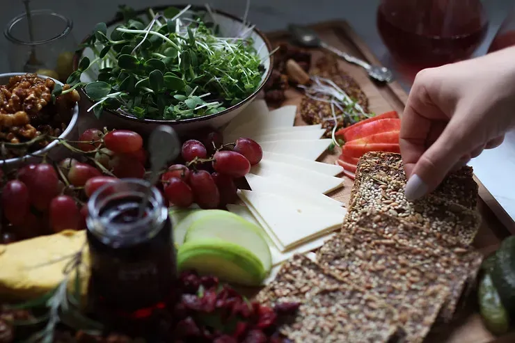 A board of various fruit, veggies and bread