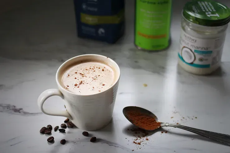 A mug of coffee and a spoon next to it