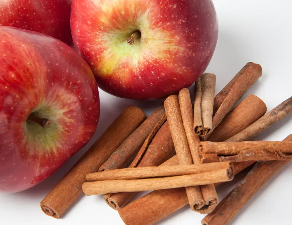 Apple and Cinnamon sticks sitting on a table