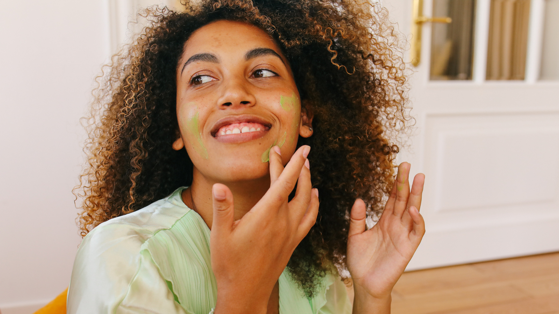 A woman applying skin care cream to her face