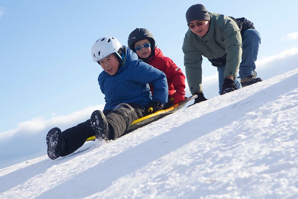 A family goes tobogganing in the winter 