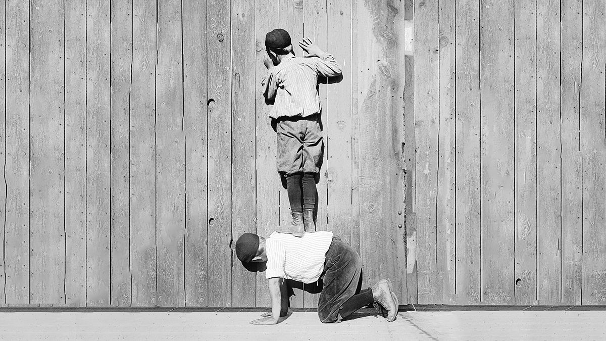 child helping another one reach higher