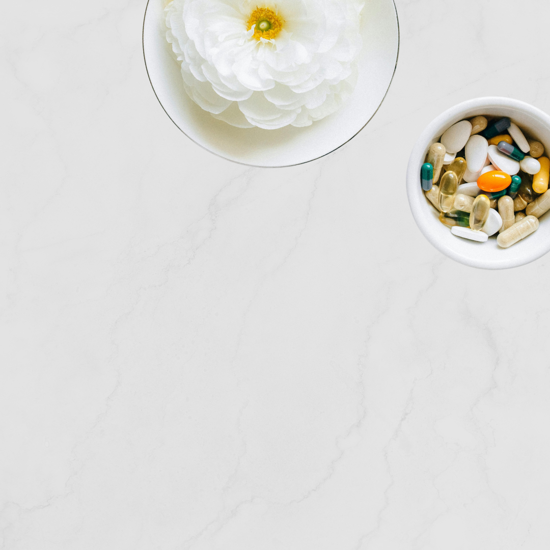 Bowl of supplements next to a white flower
