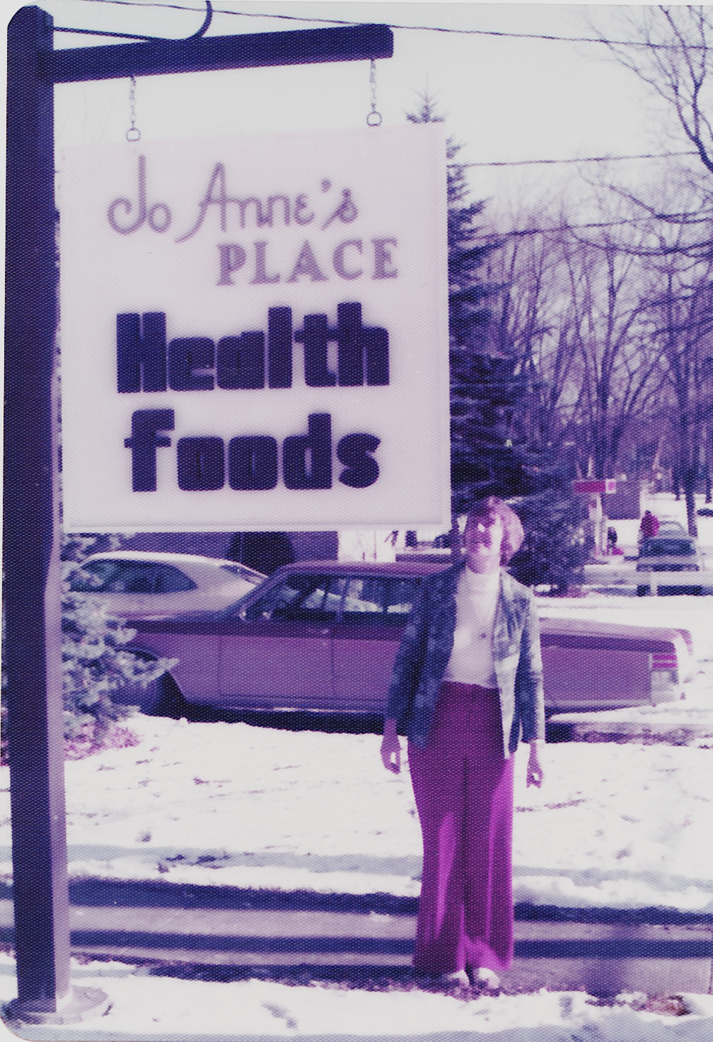An old photo of our founder, Jo Anne, in front of the original building