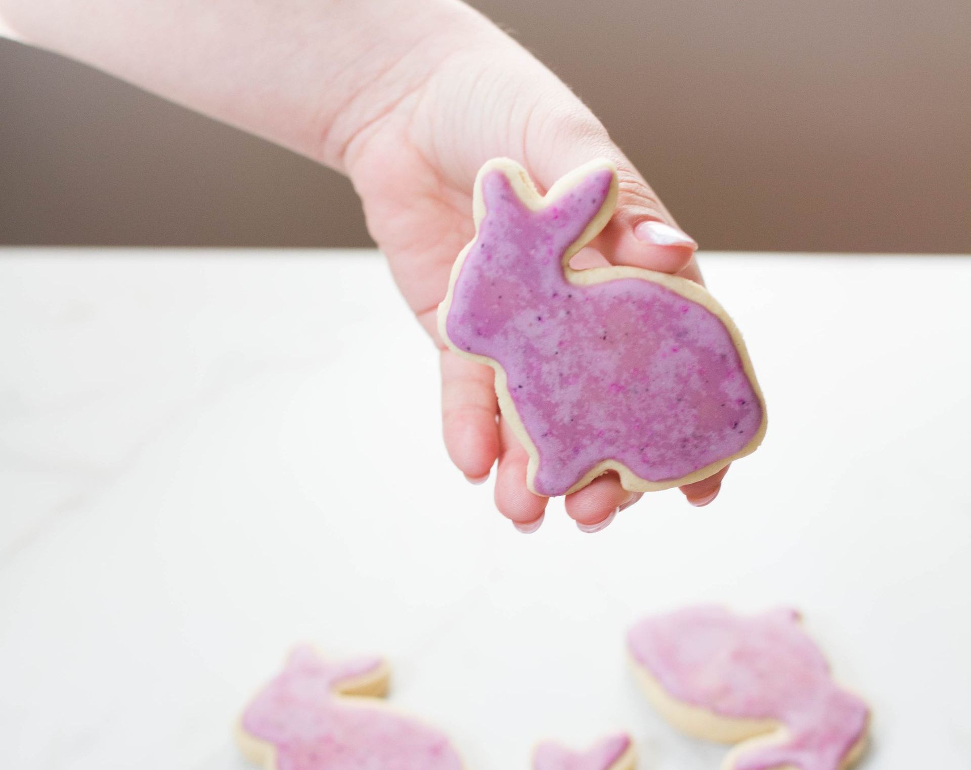 A cookie made to look like a bunny rabbit with pink frosting