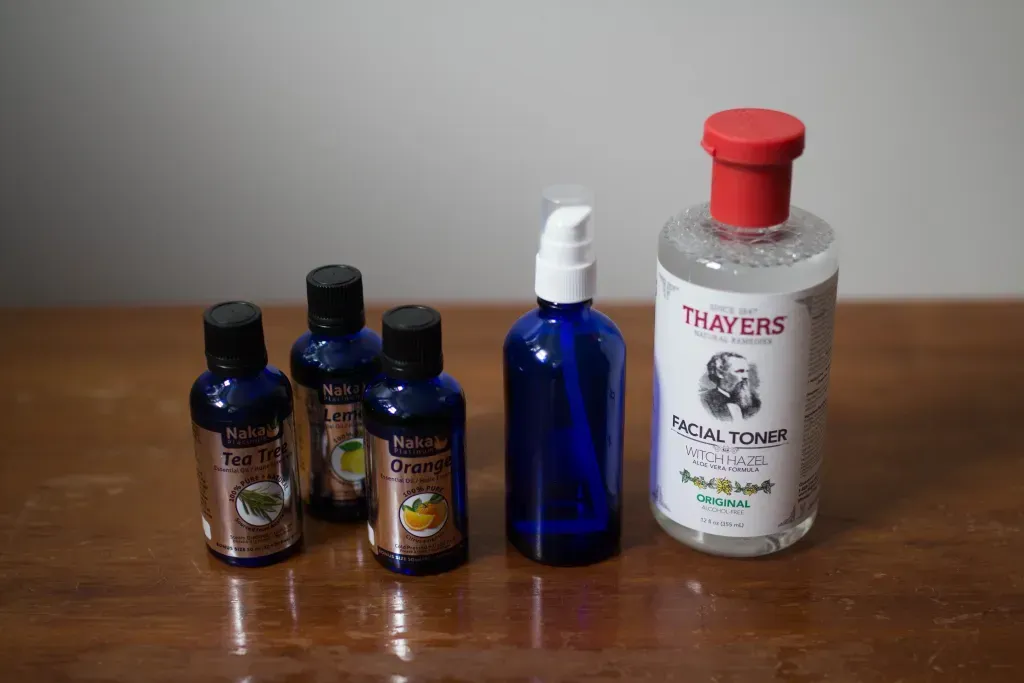 essential oils, glass blue spray bottle, witch hazel toner