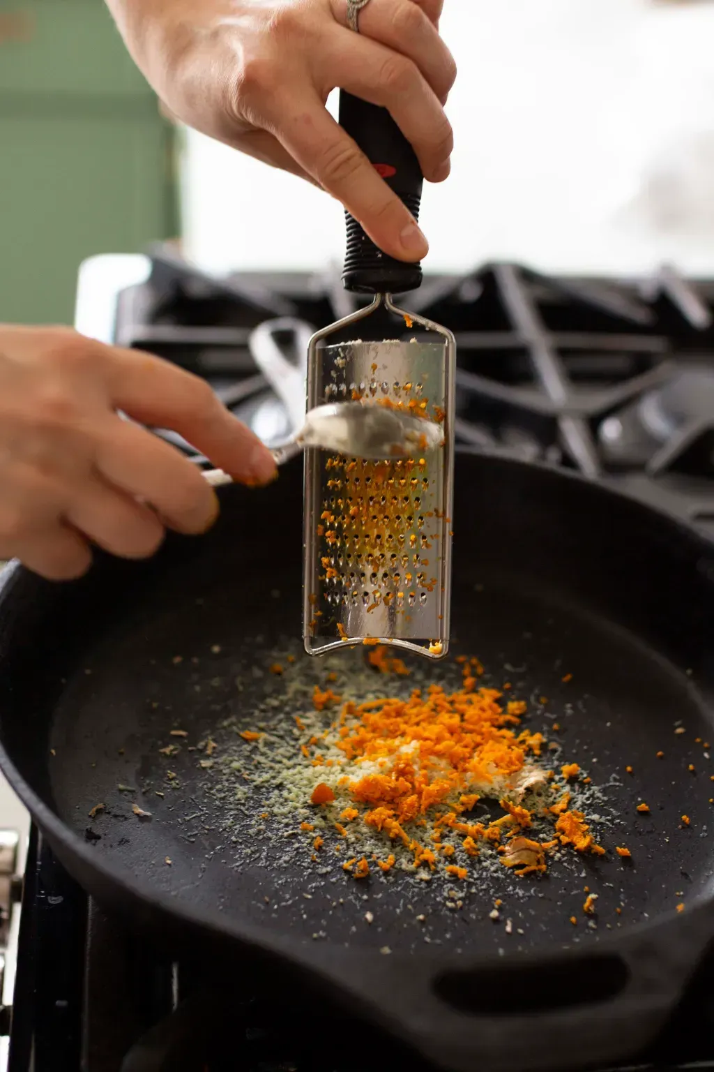 grating a carrot into a pan