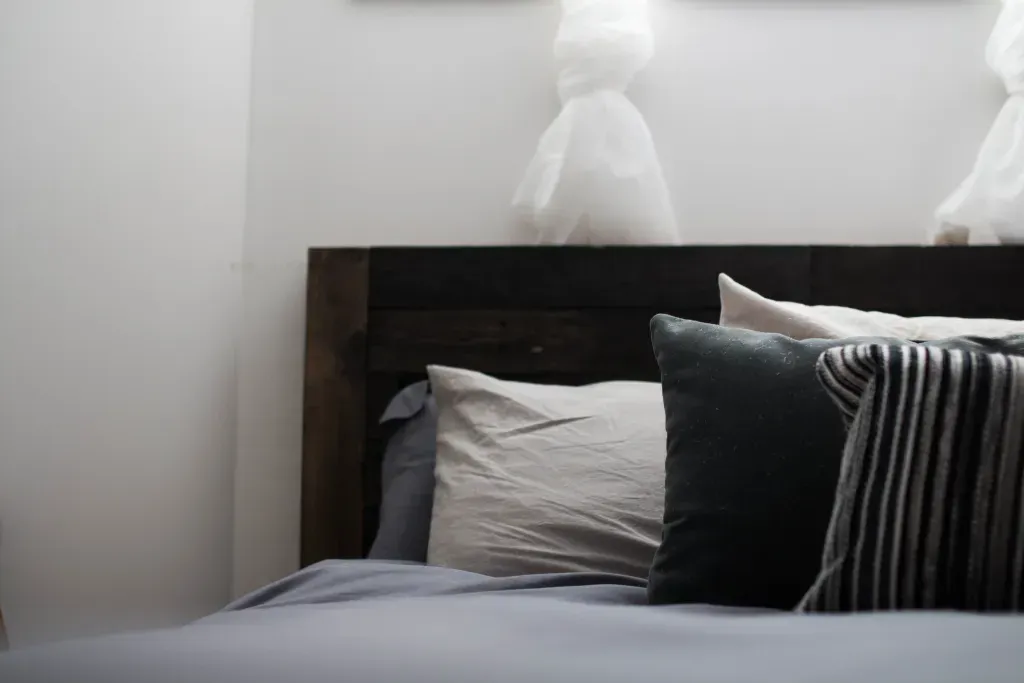 A bed with black and grey pillows