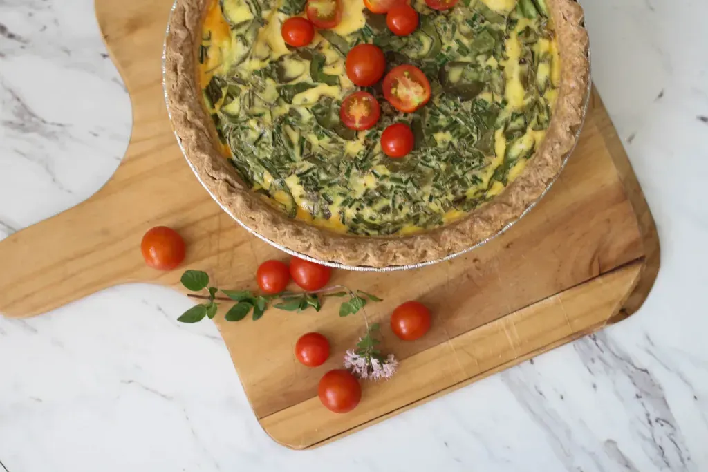 A Quiche sitting on a cutting board