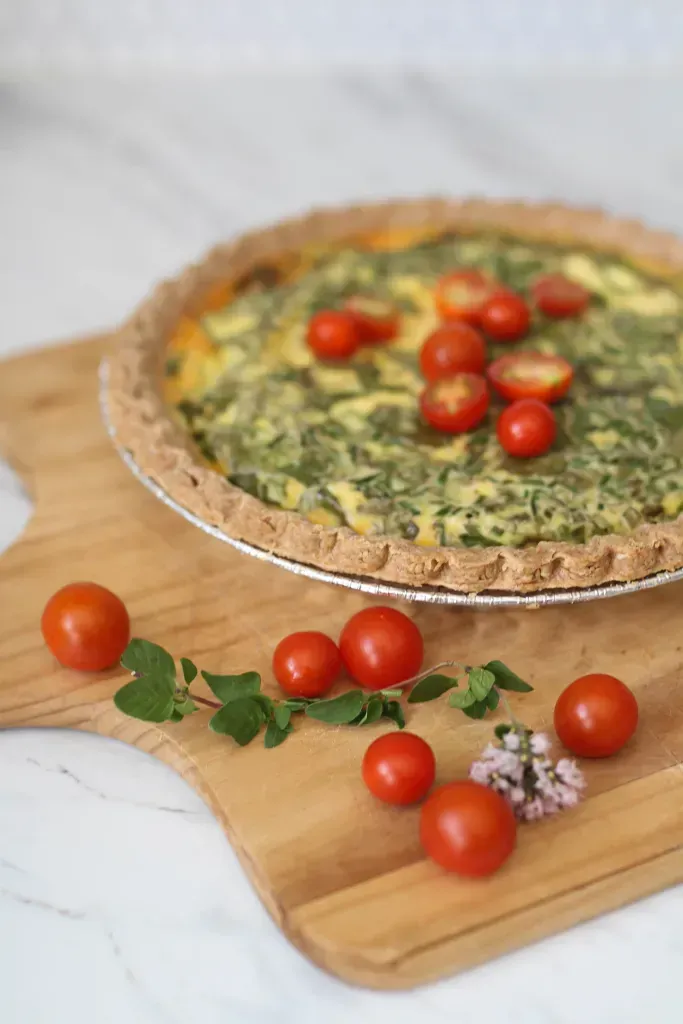 quiche garnished with baby tomatoes and herbs