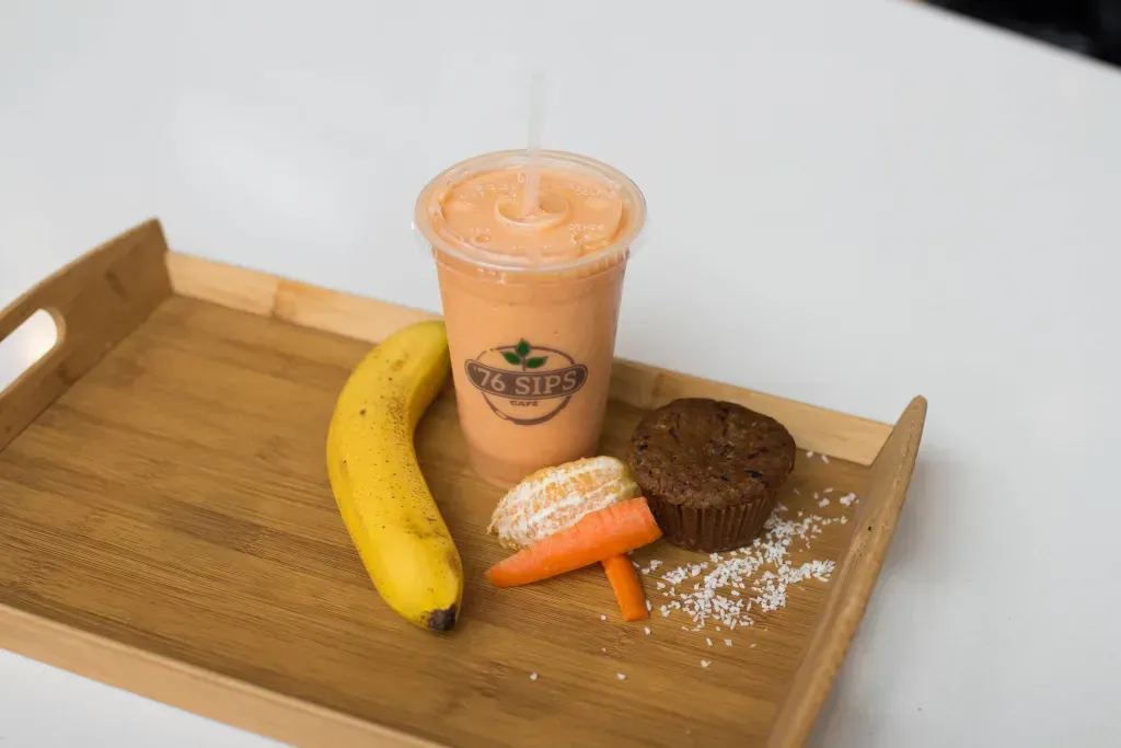 Sunrise Muffin next to a smoothie, banana, orange, and carrot