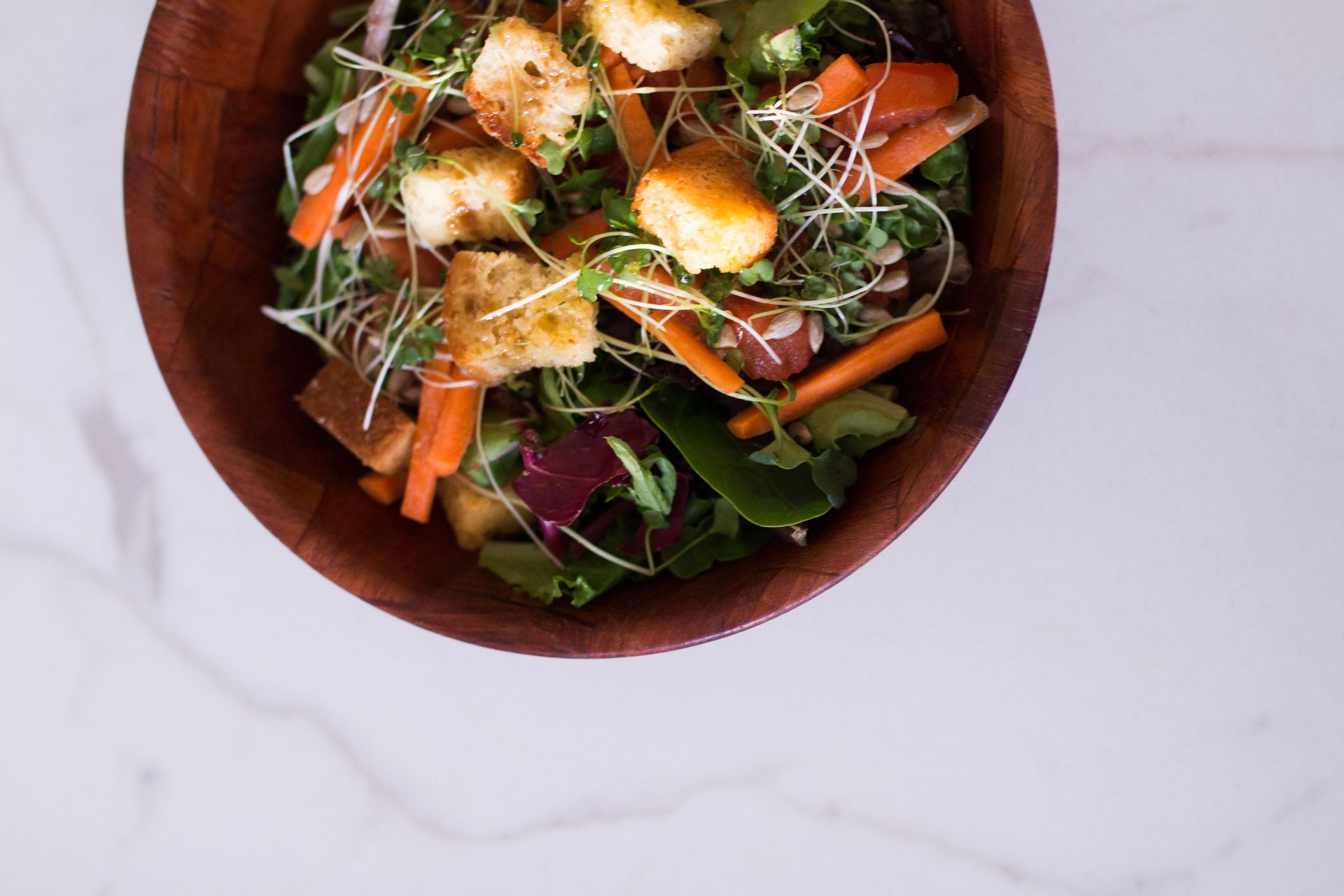 Salad bowl of carrots, lettuce, croutons and cheese