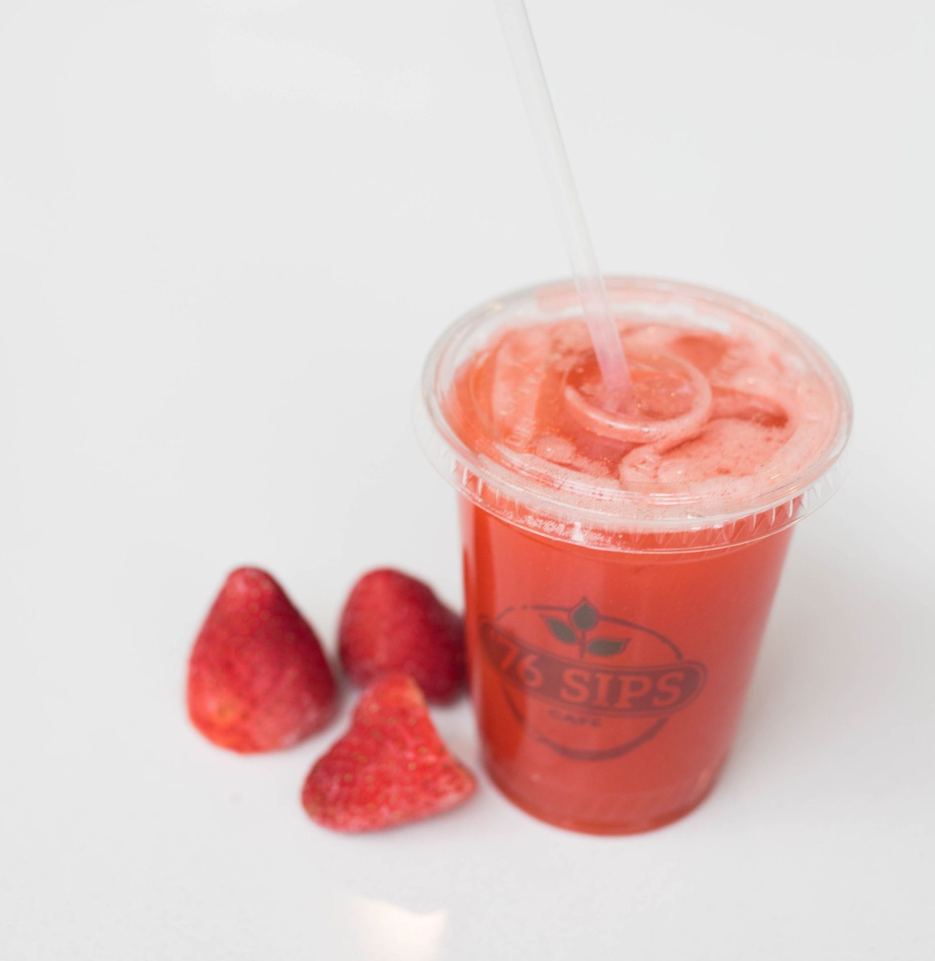 A red smoothie in a plastic cup