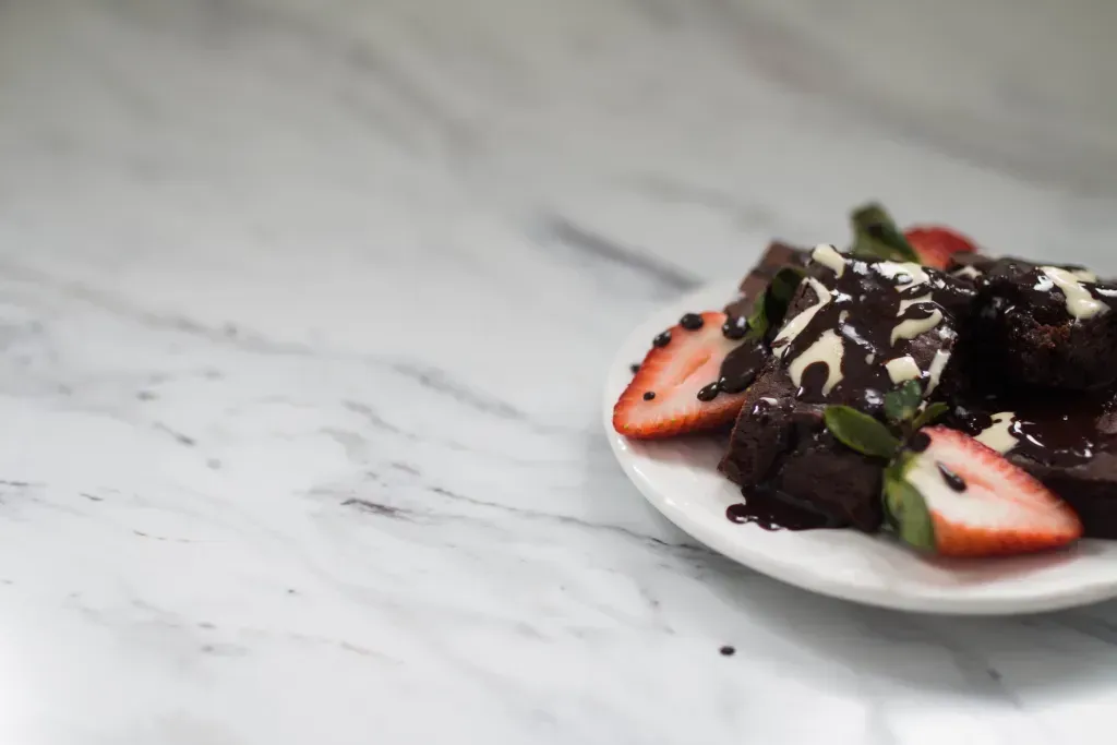 gluten free chocolate brownies on a plate with strawberries