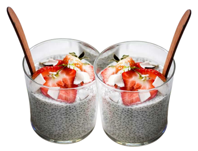 Two glasses containing Holiday Spice Chia Coconut Pudding sit next to each other with wooden spoons sticking out.