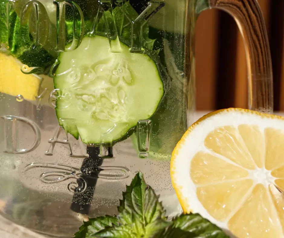 Lemons and cucumbers sit in a jar of water