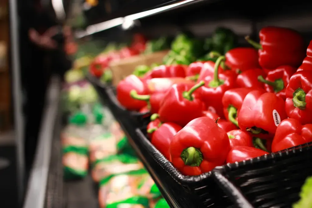Red Peppers sit in a basket on a store shelf