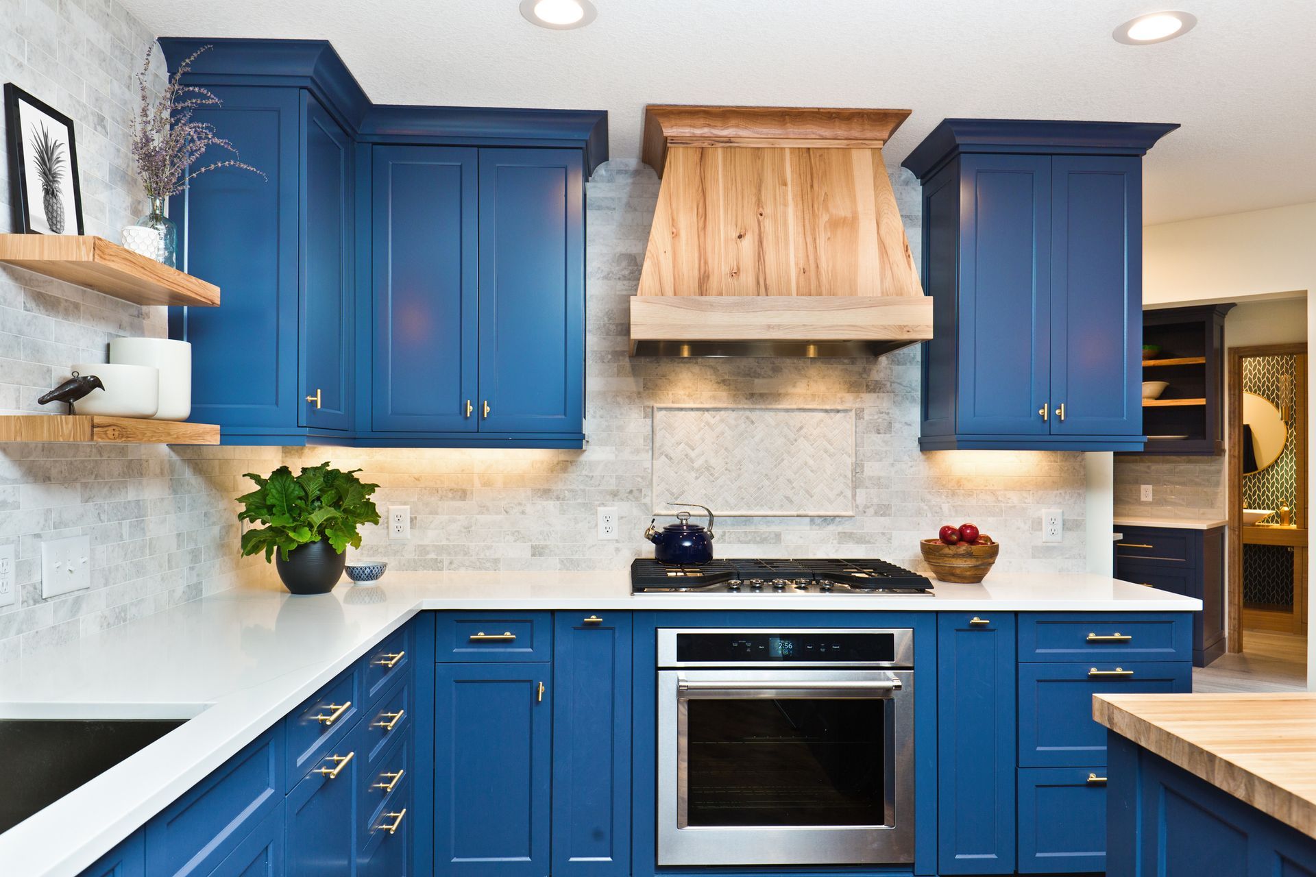 A kitchen with blue cabinets and stainless steel appliances.