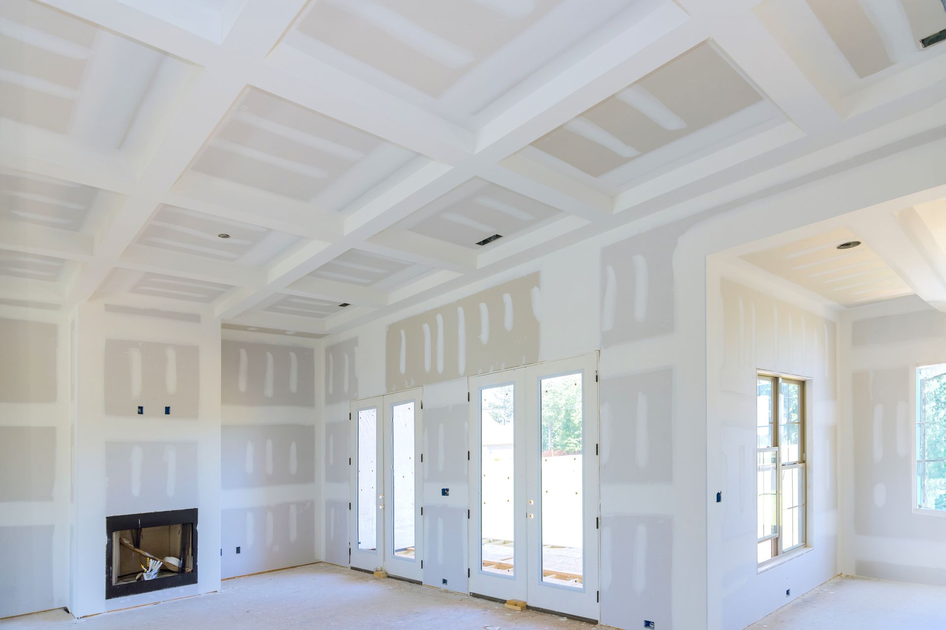 A living room in a house under construction with a fireplace and lots of windows.