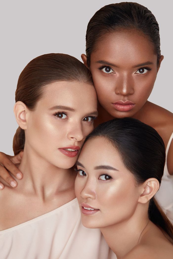 Three women of different races are posing for a picture together. Three women posing for a picture together.