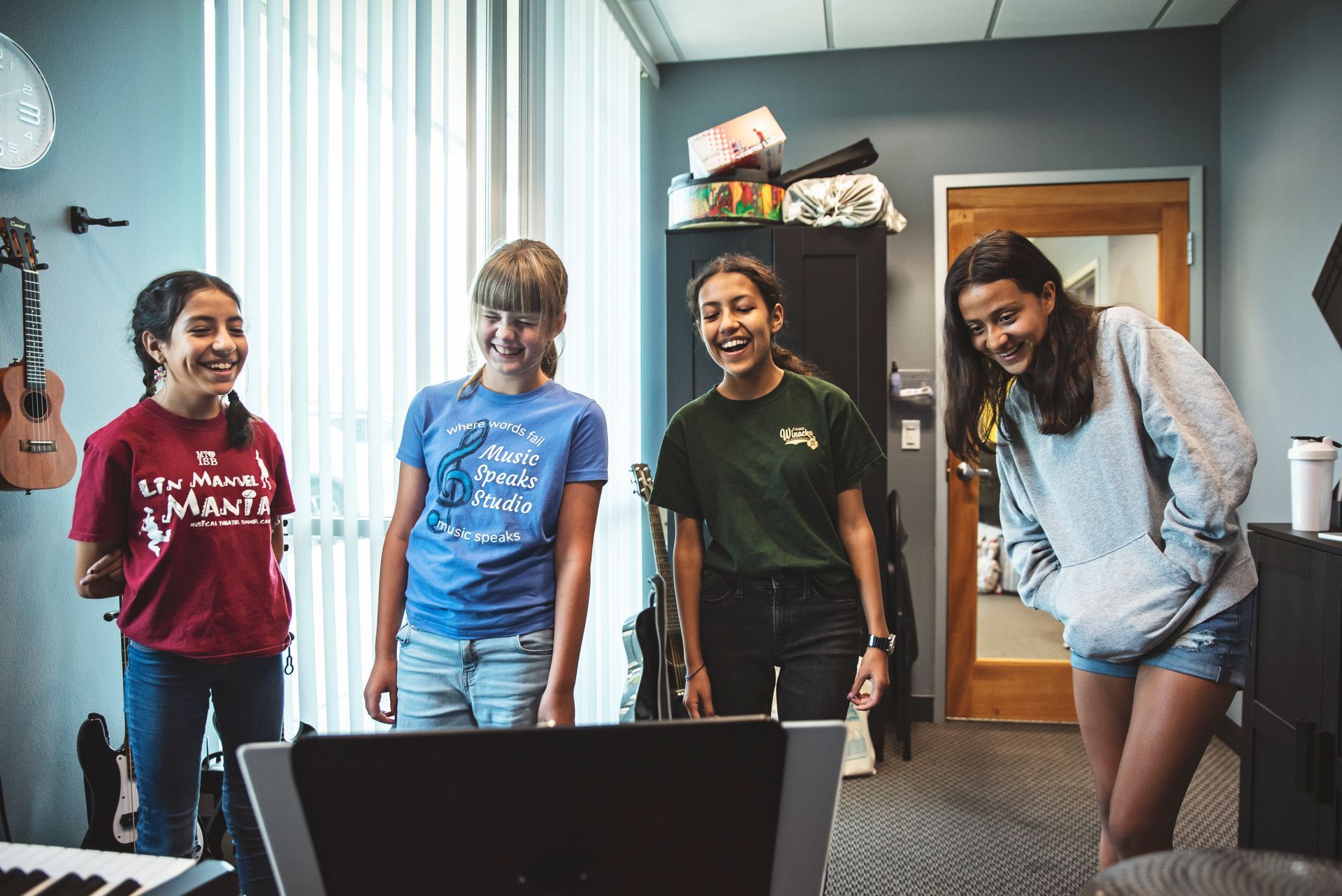 A group of young girls are standing next to each other in a room.