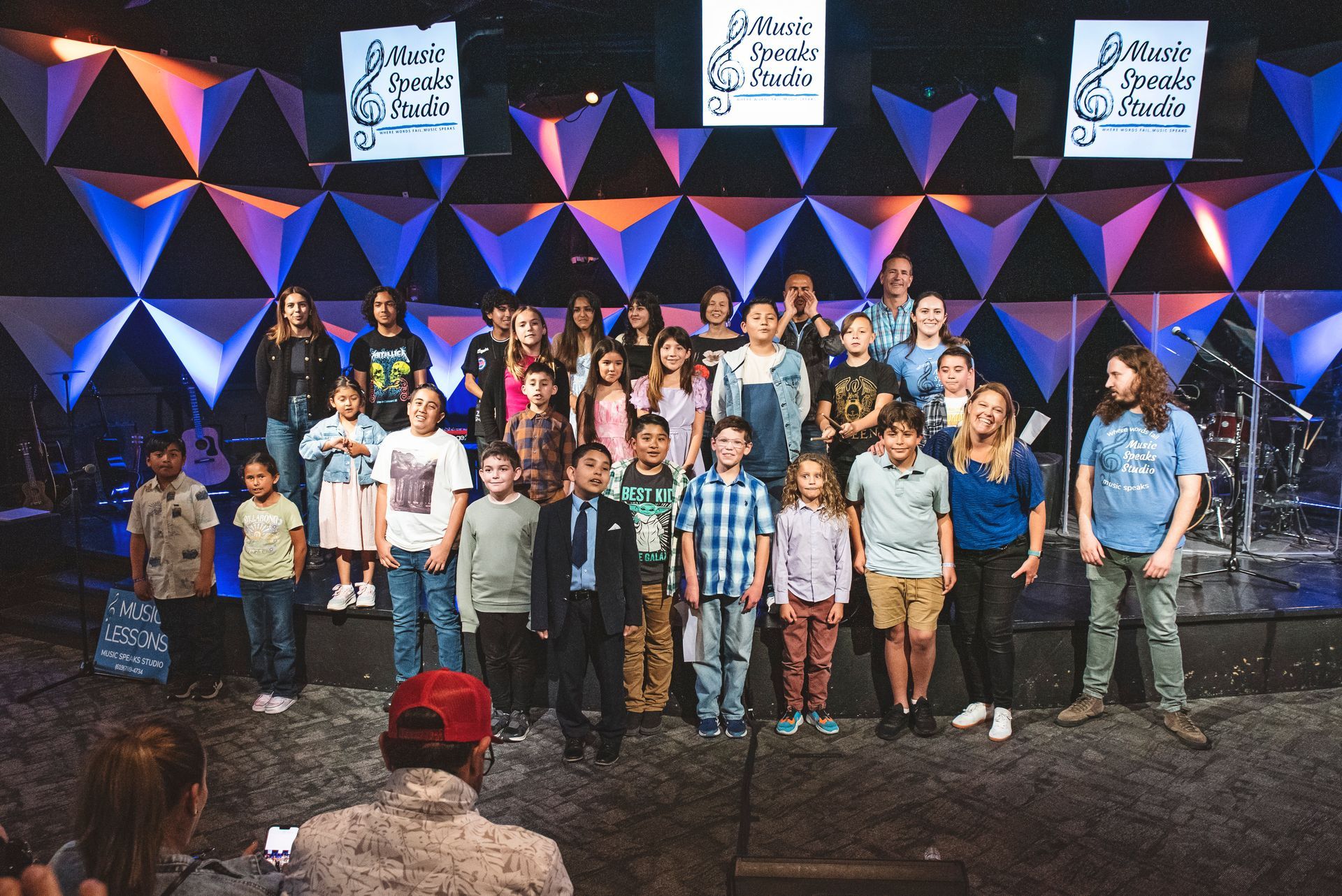 A group of children are posing for a picture on a stage.